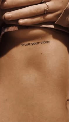 a woman's stomach with the words trust your vibes written on it