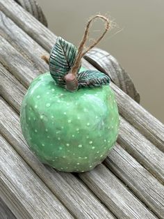 a green apple sitting on top of a wooden bench