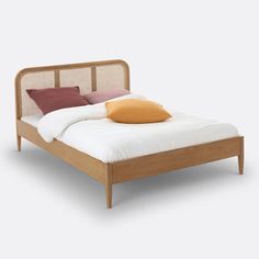 a bed with two pillows on top of it and a wooden frame around the headboard