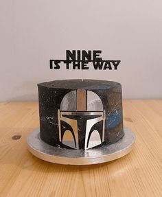 a star wars themed cake with the words nine is the way on it and a boba fett helmet