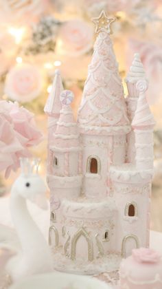 there is a pink castle with white frosting on it and flowers in the background