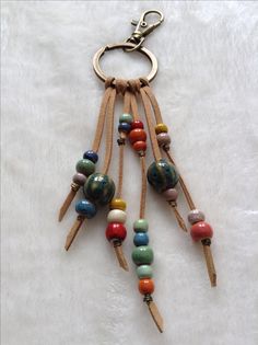 a keychain with several different beads hanging from it's side on a white surface