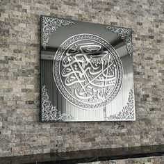 an intricately designed metal plaque on the side of a brick building with arabic writing