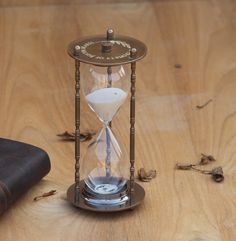 an hourglass sitting on top of a wooden table