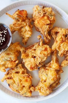 a white plate topped with fried chicken and dipping sauce