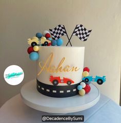 a birthday cake with race cars and flags on the top is ready to be eaten