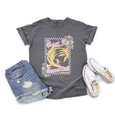 Looking for a cute versatile top to wear? Make sure to grab one of our Graphic tees! This soft and comfortable graphic tee is the perfect top for any outfit. It can be paired with biker shorts, jeans, or even a simple skirt/dress! This tee is true-to-size, so be sure to order your regular t-shirt size! If you are looking for a more oversized look, make sure to size up! Trendy Acid Wash T-shirt With Letter Print, Trendy Acid Wash Cotton T-shirt, Trendy Acid Wash T-shirt With Graphic Print, Trendy Tie Dye T-shirt With Graphic Print, Trendy Acid Wash Tops With Screen Print, Trendy Acid Wash T-shirt With Text Print, Trendy Faded Soft-washed T-shirt, Trendy Relaxed Fit Faded T-shirt, Acid Wash Cotton Top With Slogan