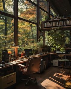 a home office with large windows and lots of books on the shelves, along with a computer desk