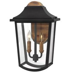 an outdoor wall light with two candles on the front and back of it, in black