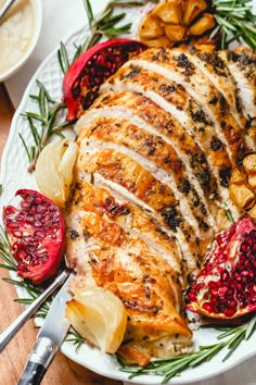 a white plate topped with chicken and pomegranates