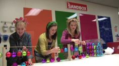 three girls are playing with ornaments on the table