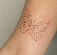 a small butterfly tattoo on the arm with words written below it and an outline of a butterfly