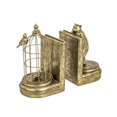 two golden metal birdcages sitting next to each other on top of a book