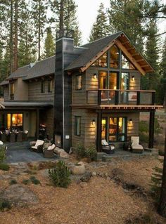 a house in the woods with lots of windows and lights on it's roof