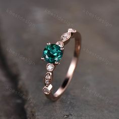 an engagement ring with a blue heart shaped stone and three diamonds on the side, sitting on top of a rock