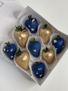 chocolate covered strawberries with gold leaf decorations in a white box on top of a table