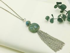 "Chain Tassel Necklace, Long Pendant Necklace, Long Necklaces for Women, Boho Tassel Necklace, Boho Necklace for Women, Long Silver Necklace This gorgeous tassel necklace brings boho vibes. This beauty has a generous 3 inch tassel made from pieces of antique silver textured cable chain; it's topped with two beautiful bluish, green ceramic focal beads, along with a silver floral bead cap & an antique silver textured decorative ring. A matching antique silver textured cable chain & a lobster clasp closure completes the necklace. Length of Necklace: 29 inches ---  Chain: Antique Silver Plated Stainless Steel -------  A 2 inch extender chain is included----  Pendant: 1.25 L X 1\" W Ceramic Bead & .25\" Ceramic Topper Bead --------   Closure: Lobster Clasp  Please note: Due to the one of a kind Tassel Jewelry With Round Beads For Gifts, Gift Jewelry With Tassels And Round Beads, Handmade Dangle Tassel Necklace For Gift, Tassel Necklace With Round Beads For Gifts, Green Tasseled Jewelry For Gifts, Pendant Necklace Long, Tassel Necklace Boho, Long Silver Necklace, Long Necklaces