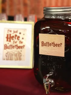 a jar of beetbeer sitting on top of a table next to a framed sign