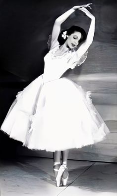 a black and white photo of a woman in a ballerina dress with her arms stretched out