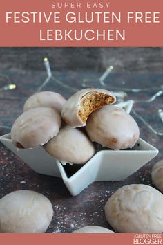 a white bowl filled with donuts on top of a wooden table next to christmas lights