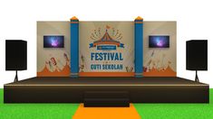 a stage set up for a festival with speakers on the side and an orange carpet