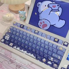 an open laptop computer sitting on top of a desk next to a teddy bear figurine