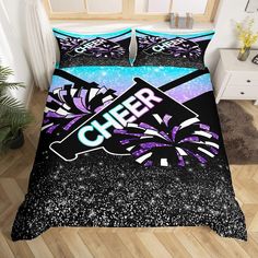 a bed covered in purple and black comforter with the word cheer written on it