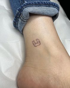 a small tattoo on the ankle of a woman's foot, with an elephant