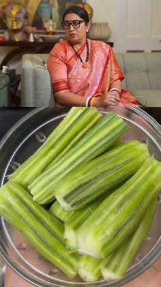 a woman holding up a plate full of celery