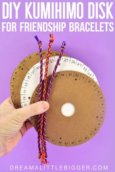 a hand holding two pieces of paper with the words diy kumimo disk for friendship bracelets