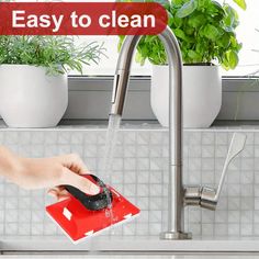 a person is washing their hands under a faucet in the kitchen sink with an easy to clean sponge