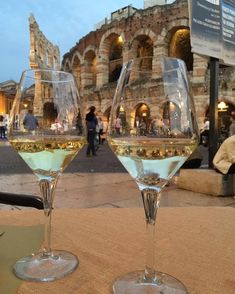 two wine glasses sitting on top of a table