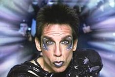 a man with his face painted in purple and black is looking at the camera while he's surrounded by bright lights