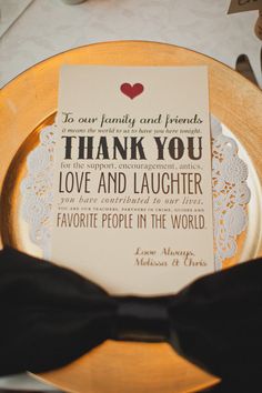 a thank you card on a plate with a black bow tie