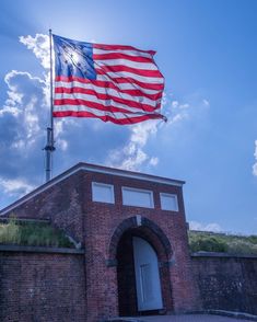 an american flag flying over a brick building