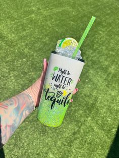 a person holding up a green cup with a lime slice on it and the words made in water