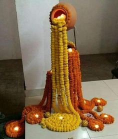 an arrangement of corn on the cob with candles around it and flowers all over the floor