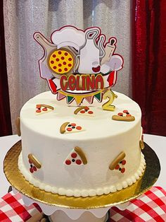 a white cake sitting on top of a table next to a red and white checkered table cloth