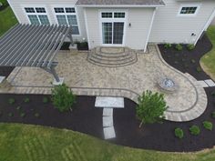 an aerial view of a house with patio and pergolated area in the front yard