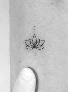 a small lotus flower tattoo on the wrist