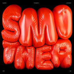 the words smile are made out of red plastic balloons and sit on top of each other