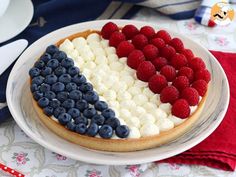 an american flag pizza on a plate with raspberries and blueberries