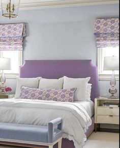 a bedroom with purple and white decor on the walls