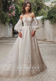 a woman in a wedding dress standing on a brick walkway with her hands on her hips