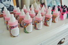 baby bottles filled with candy and candies on top of a table next to a framed photo