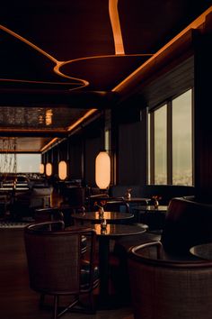 a dimly lit restaurant with round tables and chairs