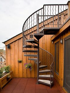 a metal spiral staircase next to a wooden building