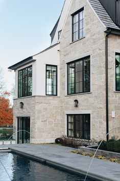 a house with a pool in front of it and water spouting from the side