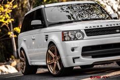 a white range rover is parked on the street