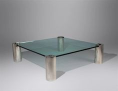 a glass table with two metal legs on it